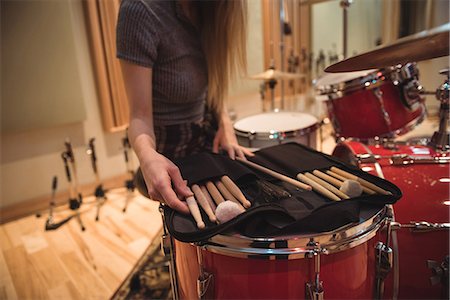 simsearch:6109-08802462,k - Mid section of woman looking at drum sticks in recording studio Stock Photo - Premium Royalty-Free, Code: 6109-08802439