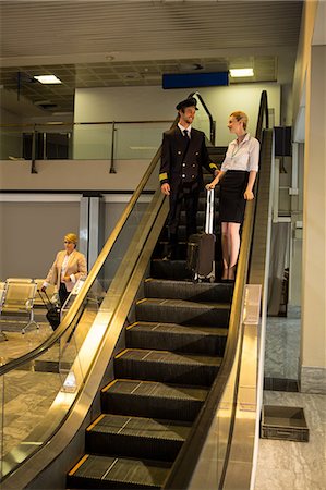 simsearch:400-07752842,k - Pilot and staff having a conversation on the escalator in the airport terminal Stock Photo - Premium Royalty-Free, Code: 6109-08802695