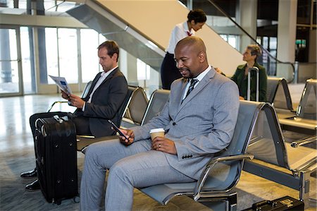 simsearch:6109-08700193,k - Businessman using mobile phone in waiting area at airport terminal Stock Photo - Premium Royalty-Free, Code: 6109-08802757
