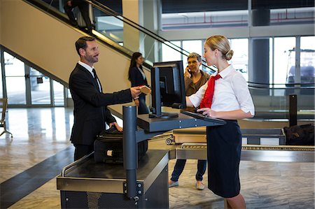 Female staff interacting with passenger at the airport terminal Stock Photo - Premium Royalty-Free, Code: 6109-08802725