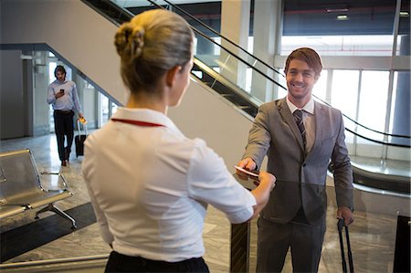 simsearch:6109-08929511,k - Female staff checking boarding pass of passengers at check-in counter in airport Stockbilder - Premium RF Lizenzfrei, Bildnummer: 6109-08802865