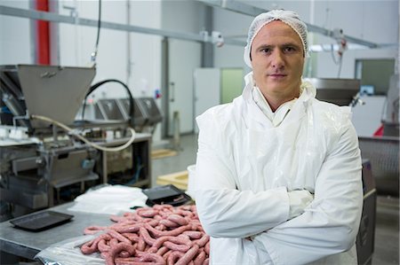Portrait of male butcher standing with arms crossed at meat factory Photographie de stock - Premium Libres de Droits, Code: 6109-08802874