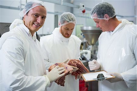 proteina - Butchers maintaining records on clipboard at meat factory Fotografie stock - Premium Royalty-Free, Codice: 6109-08802883