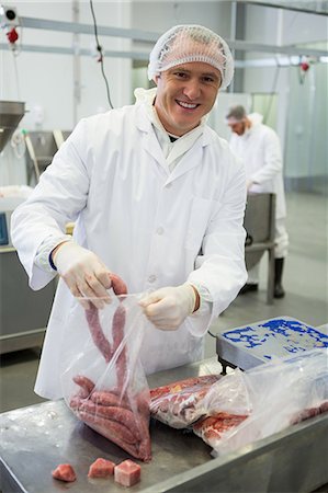 paquet (contenant) - Portrait of male butcher packing raw sausages at meat factory Photographie de stock - Premium Libres de Droits, Code: 6109-08802882