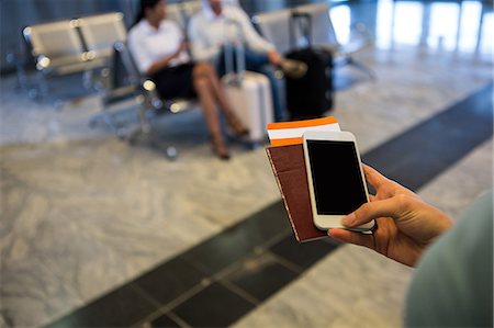 Woman hand holding Smartphone, passport and boarding pass at airport terminal Foto de stock - Sin royalties Premium, Código: 6109-08802819