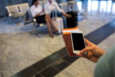 smartphone women - Woman hand holding Smartphone, passport and boarding pass at airport terminal Stock Photo - Premium Royalty-Free, Code: 6109-08802819