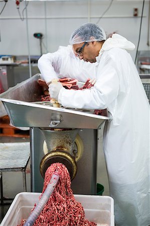 Butchers placing meat in mincing machine at meat factory Stock Photo - Premium Royalty-Free, Code: 6109-08802953