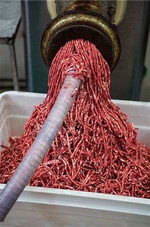 Minced meat coming out from grinder at meat factory Stock Photo - Premium Royalty-Free, Code: 6109-08802954