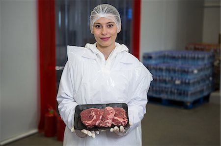 simsearch:6109-08764471,k - Portrait of female butcher holding a meat tray at meat factory Foto de stock - Sin royalties Premium, Código: 6109-08802974