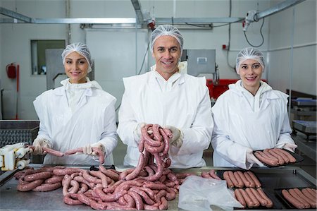 Portrait of butchers packing sausages at meat factory Foto de stock - Sin royalties Premium, Código: 6109-08802981