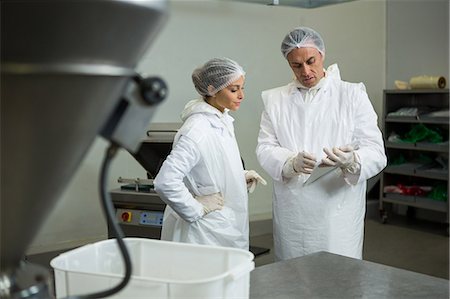 Butchers discussing over clipboard at meat factory Photographie de stock - Premium Libres de Droits, Code: 6109-08802986