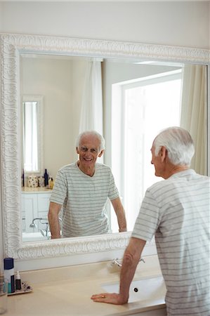 simsearch:6109-08435552,k - Senior man looking at mirror in bathroom Fotografie stock - Premium Royalty-Free, Codice: 6109-08803148