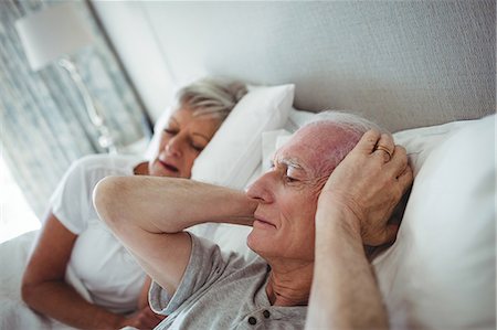 ronfler - Senior man lying on bed and covering his ears with hands in bedroom Photographie de stock - Premium Libres de Droits, Code: 6109-08803184