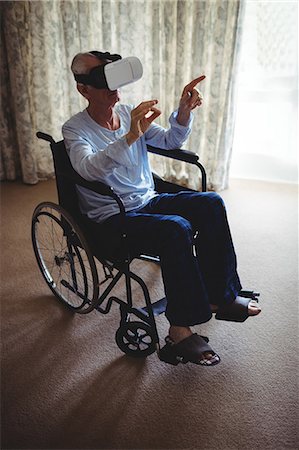 Senior man sitting on wheelchair and using virtual reality headset in bedroom at home Foto de stock - Sin royalties Premium, Código: 6109-08803131