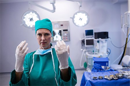 simsearch:6109-08720095,k - Portrait of female surgeon wearing surgical gloves in operation theater of hospital Stock Photo - Premium Royalty-Free, Code: 6109-08803208