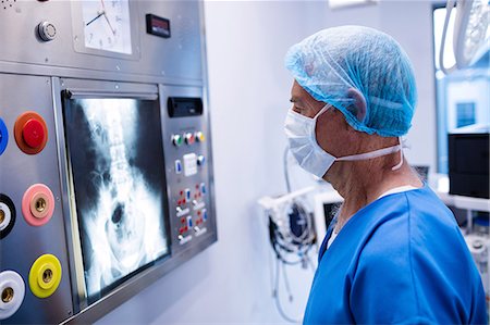 surgeon - Male surgeon reading x-ray in operation theater Photographie de stock - Premium Libres de Droits, Code: 6109-08803210