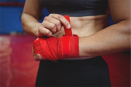 simsearch:6109-08803752,k - Mid section of female boxer wearing red strap on wrist in fitness studio Photographie de stock - Premium Libres de Droits, Code: 6109-08803754