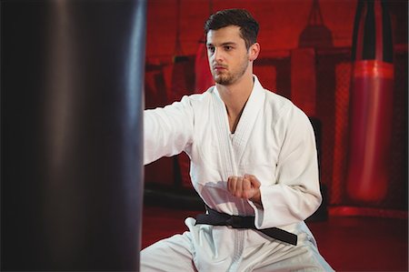 simsearch:400-03922328,k - Karate player performing karate stance in fitness studio Photographie de stock - Premium Libres de Droits, Code: 6109-08803756