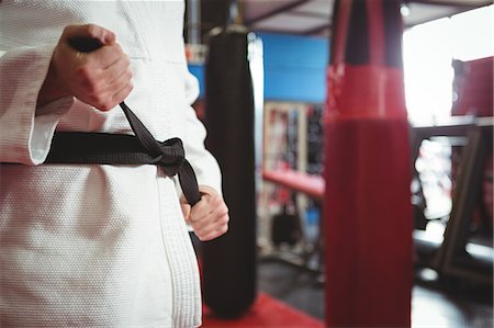 soldat américain - Mid section of karate player tying his belt in fitness studio Photographie de stock - Premium Libres de Droits, Code: 6109-08803789