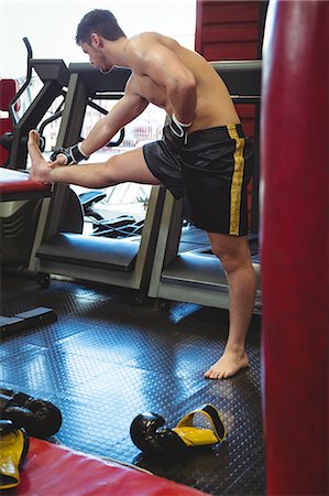 Boxer doing stretching exercise in fitness studio Stock Photo - Premium Royalty-Free, Code: 6109-08803709