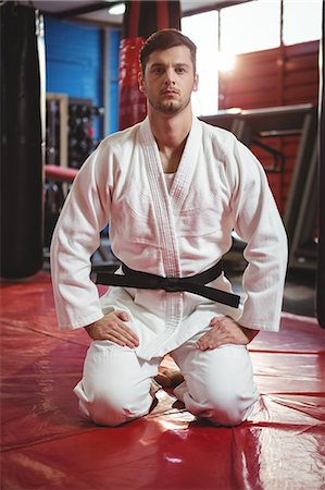 simsearch:6109-08803723,k - Portrait of karate player performing karate stance in fitness studio Fotografie stock - Premium Royalty-Free, Codice: 6109-08803724