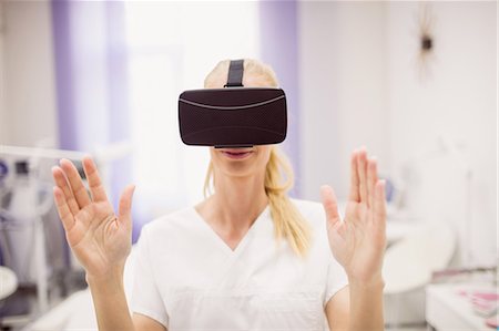 Female doctor wearing virtual reality headset in clinic Stock Photo - Premium Royalty-Free, Code: 6109-08803852