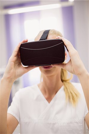 Female doctor wearing virtual reality headset in clinic Stock Photo - Premium Royalty-Free, Code: 6109-08803855