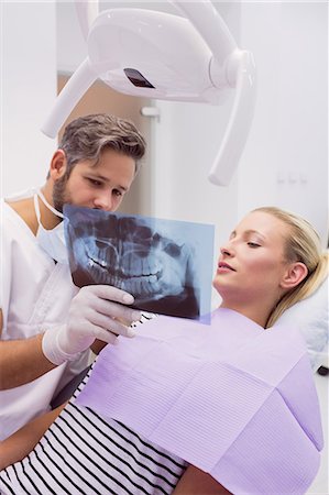 dishonesty - Dentist showing x-ray to the patient in clinic Photographie de stock - Premium Libres de Droits, Code: 6109-08803891