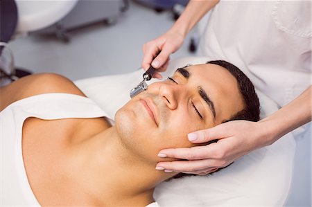 simsearch:6109-08803849,k - Dermatologist performing laser hair removal on patient face in clinic Foto de stock - Sin royalties Premium, Código: 6109-08803807
