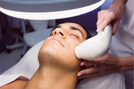 simsearch:6109-08804147,k - Man getting a facial massage for cosmetic treatment at clinic Stock Photo - Premium Royalty-Free, Code: 6109-08803811