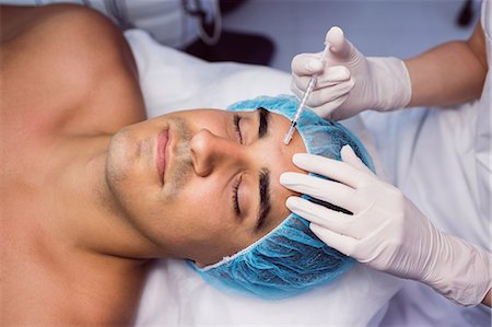 Man receiving botox injection on his forehead at clinic Photographie de stock - Premium Libres de Droits, Code: 6109-08803824