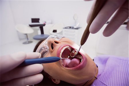 specchio da dentista - Dentist examining a female patient with tools at dental clinic 4k Fotografie stock - Premium Royalty-Free, Codice: 6109-08803944