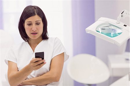 Dermatologist using mobile phone in clinic Stock Photo - Premium Royalty-Free, Code: 6109-08803970