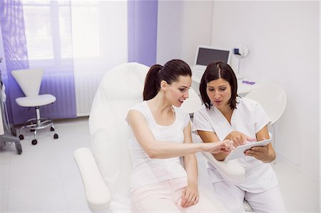Doctor and female patient discussing on digital tablet in clinic Foto de stock - Sin royalties Premium, Código: 6109-08803908