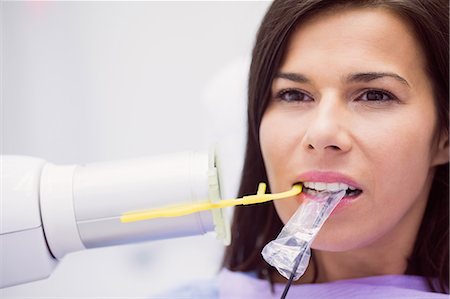 simsearch:6109-08700876,k - Female patient receiving dental treatment at dental clinic Foto de stock - Royalty Free Premium, Número: 6109-08803929