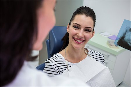 simsearch:6109-08700876,k - Female patient smiling while talking to doctor at clinic Foto de stock - Royalty Free Premium, Número: 6109-08804060