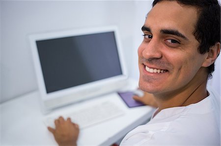 simsearch:6109-08803849,k - Portrait of smiling doctor using desktop pc at clinic Foto de stock - Sin royalties Premium, Código: 6109-08804064
