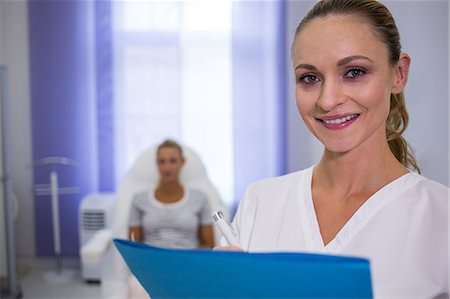 simsearch:6109-08804160,k - Portrait of smiling female doctor holding medical reports Foto de stock - Sin royalties Premium, Código: 6109-08804089