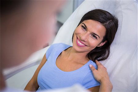 simsearch:6109-08804160,k - Female patient smiling while talking to doctor at clinic Foto de stock - Sin royalties Premium, Código: 6109-08804094