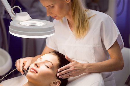 simsearch:6109-08804147,k - Dermatologist performing laser hair removal on patient face in clinic Stock Photo - Premium Royalty-Free, Code: 6109-08804016