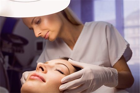 doctor advising patient in hospital - Dermatologist examining female patient skin in clinic Stock Photo - Premium Royalty-Free, Code: 6109-08804027