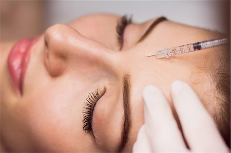 Close-up of female patient receiving an injection on her face in clinic Photographie de stock - Premium Libres de Droits, Code: 6109-08804031