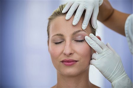 simsearch:6109-08804109,k - Doctor examining female patients face from cosmetic treatment Fotografie stock - Premium Royalty-Free, Codice: 6109-08804149