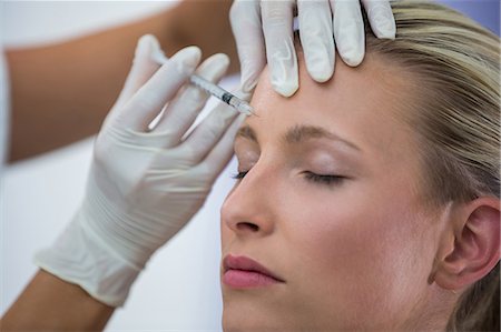 Close-up of female patient receiving a botox injection on forehead Photographie de stock - Premium Libres de Droits, Code: 6109-08804157