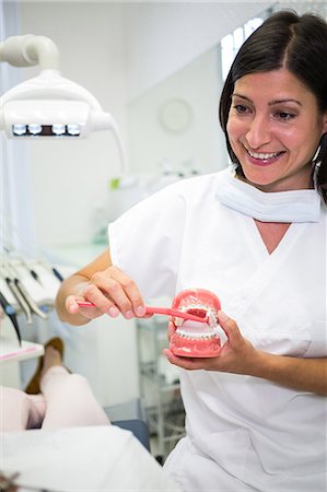 simsearch:6109-08700876,k - Dentist showing patient how to brush teeth in dental clinic Foto de stock - Royalty Free Premium, Número: 6109-08804188