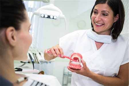 simsearch:6109-08700876,k - Dentist showing patient how to brush teeth in dental clinic Foto de stock - Royalty Free Premium, Número: 6109-08804189