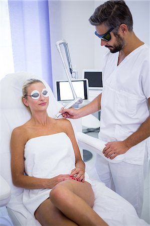 Dermatologist removing mole from womans shoulder with medical laser Fotografie stock - Premium Royalty-Free, Codice: 6109-08804118