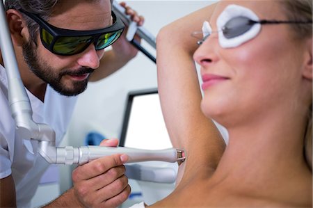 simsearch:6109-08804160,k - Dermatologist removing hair of patient armpit in beauty saloon Foto de stock - Sin royalties Premium, Código: 6109-08804122