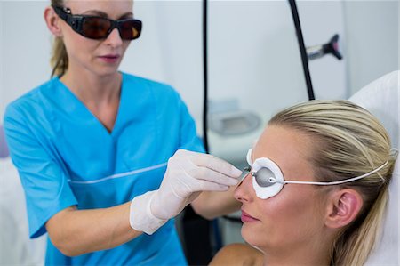 simsearch:6109-08804109,k - Dermatologist adjusting a protective glasses in a beauty saloon Fotografie stock - Premium Royalty-Free, Codice: 6109-08804128