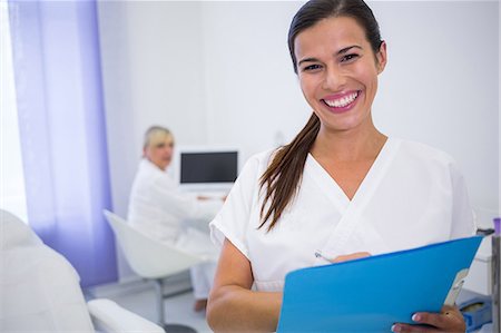 simsearch:6109-08803890,k - Portrait of smiling dentist writing a medical report in clinic Stockbilder - Premium RF Lizenzfrei, Bildnummer: 6109-08804139